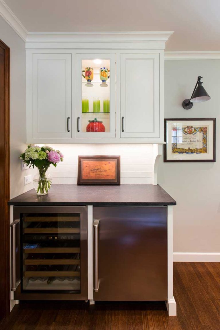 Compact home bar with dark wood cabinetry and a wine refrigerator.