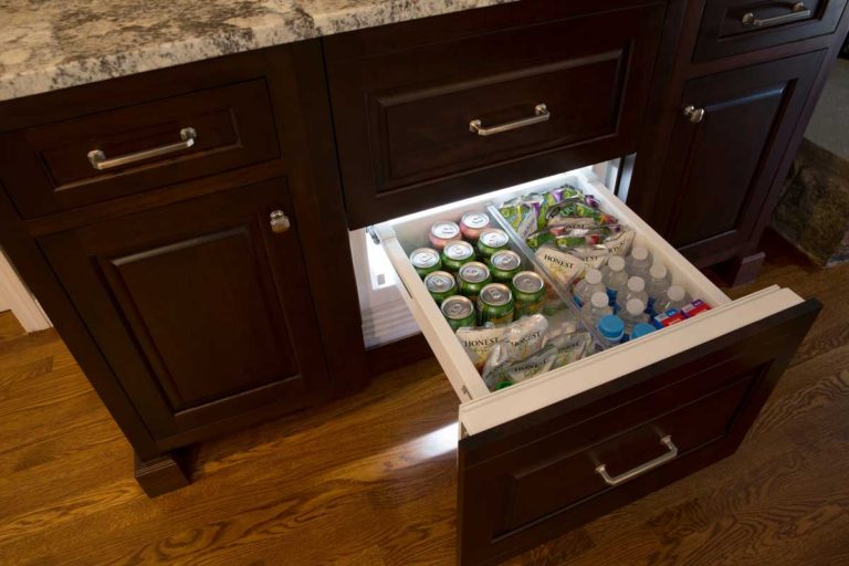Pull-out refrigerated drawer built into dark wood cabinetry.