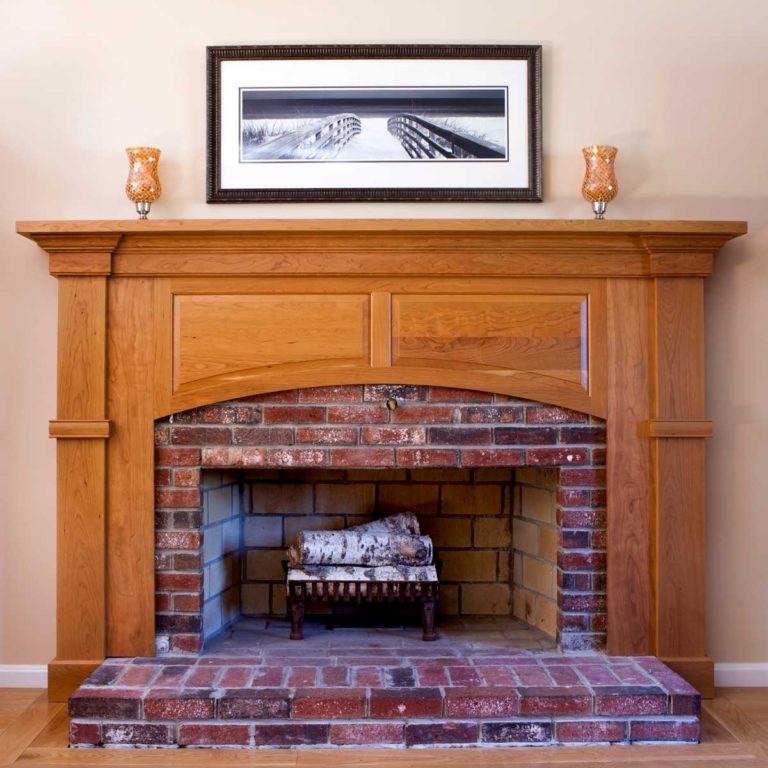 Brick fireplace with a wood mantel and built-in cabinetry.