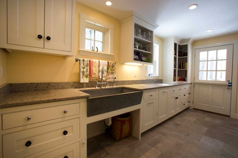 Laundry and mudroom cabinetry with a farmhouse sink and an entry door.